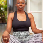 Woman sits cross-legged in peaceful yoga pose.