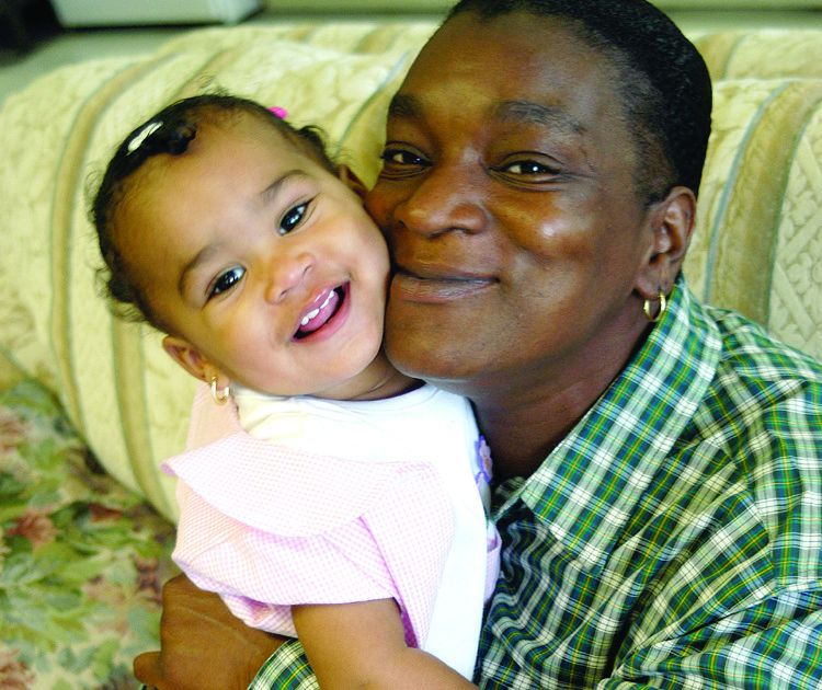 Father holds infant daughter, both smiling.